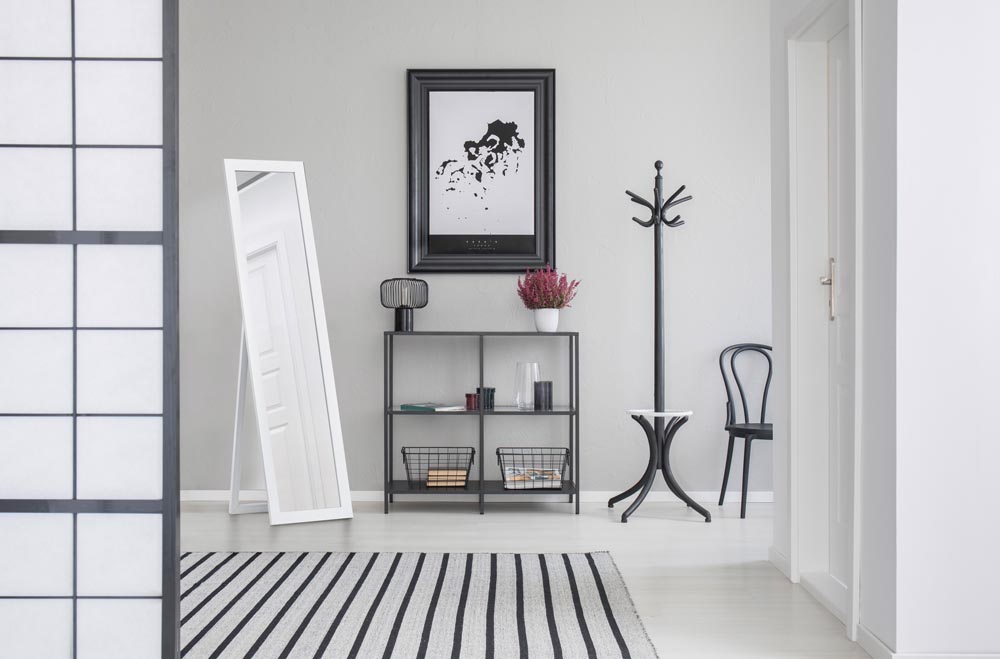 Map in black frame on the grey wall of corridor with mirror, she