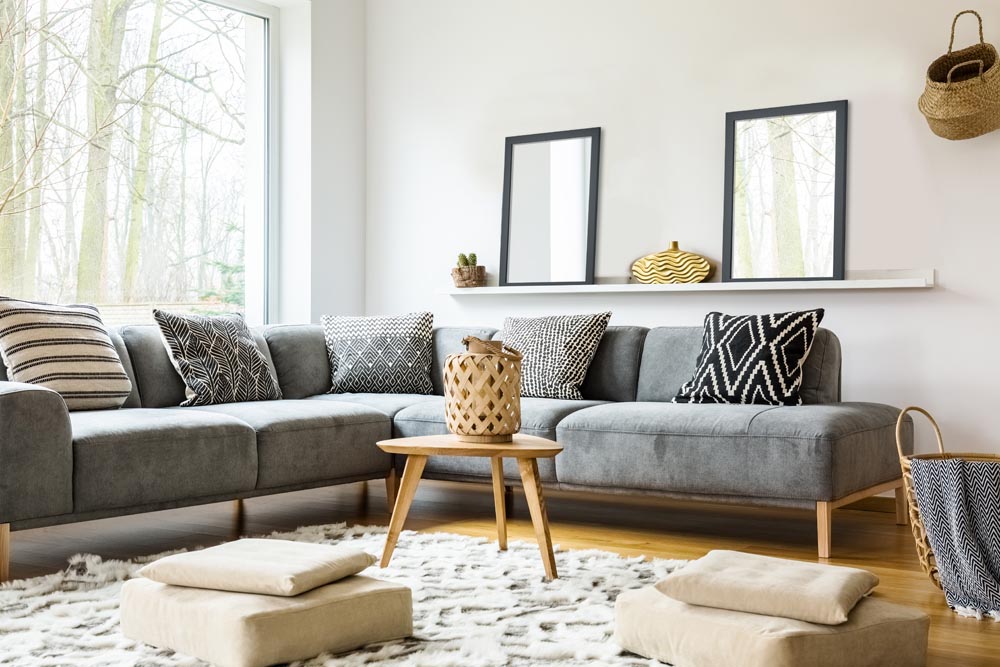Poufs on carpet in bright african living room interior with grey